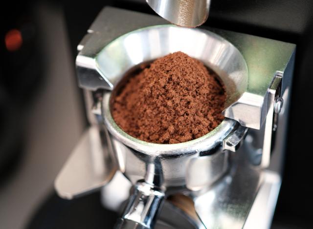 Closeup af formalet kaffe i portafilter der sidder i en espressokværn