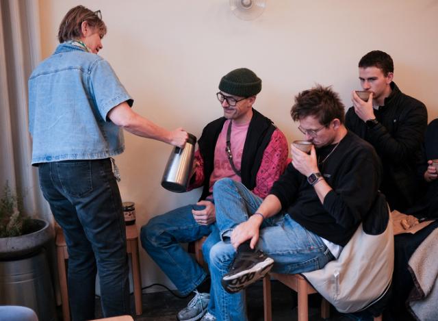 Værtinde hælder kaffe op til kursister