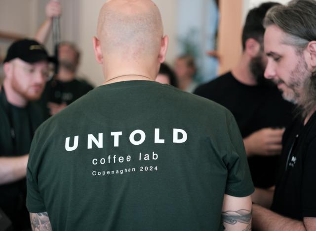 Mand med Untold-logo på ryggen er omgivet af gæster til event