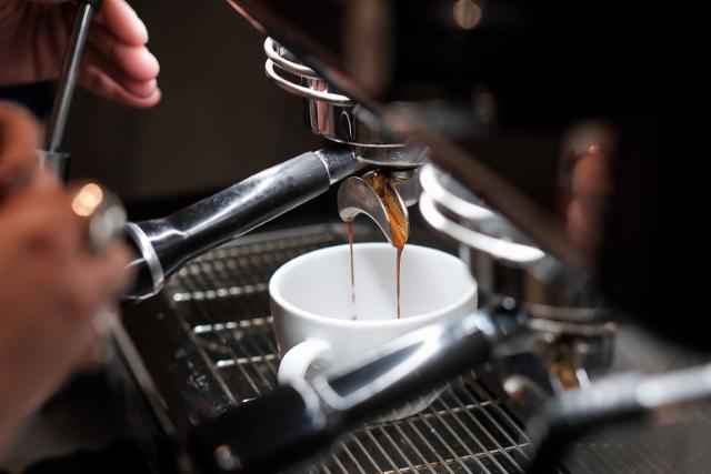 Dobbelt espressoshot løber ned i hvid porcelænskop