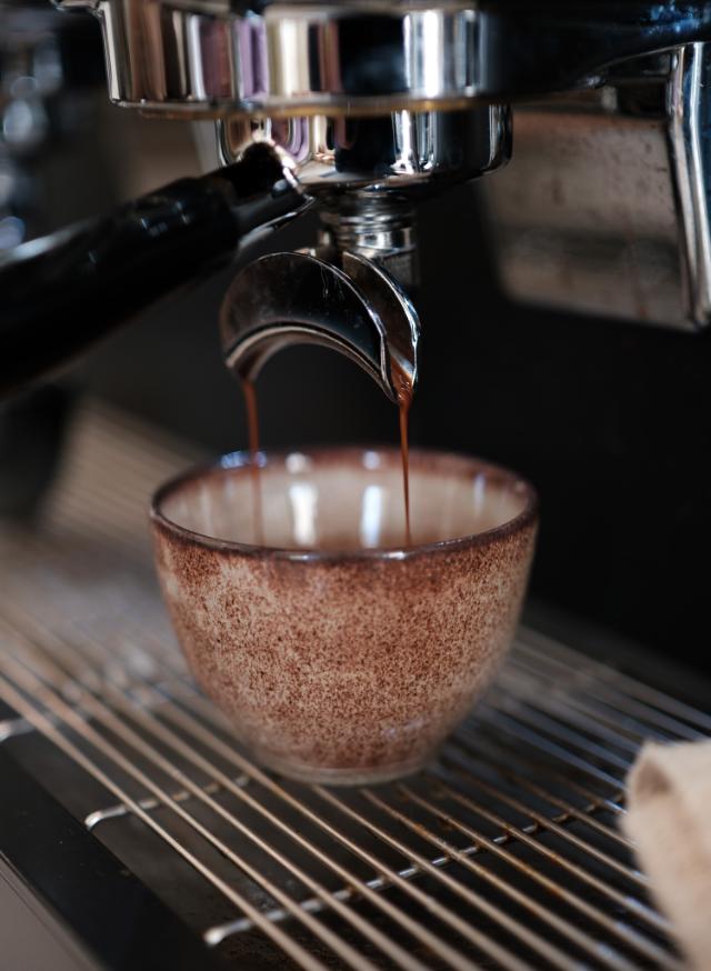 frikbrygget espressoshot løber fra maskine ned i keramisk kop