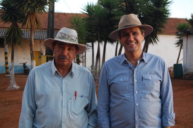 To kaffefarmere står på en farm i Brasilien med hatte på
