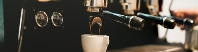 Der brygges en dobbeltespresso ned i en kop på en stor professionel espressomaskine