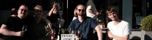 En flok gæster sidder om et bord ude foran KONTRA Coffees kaffehus