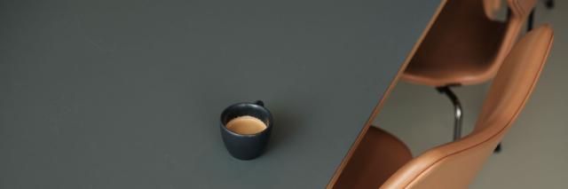 en kaffekop står på et bord med stol 