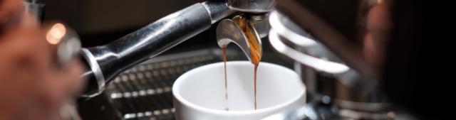 espressoshot bliver brygget på espressomaskine ned i hvid kop