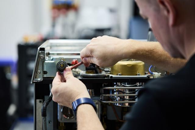 en teknikker reparerer en kaffemaskine